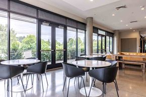 Hillsboro apartment for rent - A conference room with a table and chairs and a view of trees outside the window.