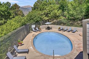 Colorado Springs apartment for rent - A small round pool surrounded by a fence and chairs.