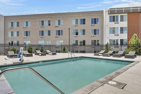 Colorado Springs apartment for rent - A swimming pool in front of a multi-story apartment building.