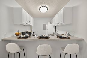 Colorado Springs apartment for rent - A kitchen with a counter and three chairs.