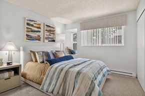 Colorado Springs apartment for rent - A bedroom with a bed, nightstand, and pictures on the wall.