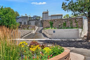 Colorado Springs apartment for rent - A building with a stone wall and a staircase leading up to it.