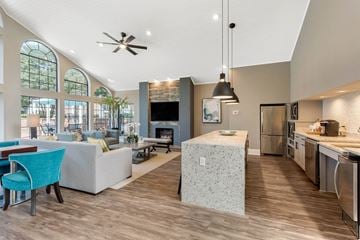 Newport News apartment for rent - A modern kitchen and living room with a blue chair and a fireplace.