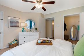 Newport News apartment for rent - A bedroom with a white bed and a ceiling fan.
