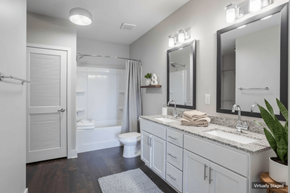 Nashville apartment for rent - A bathroom with a toilet, sink, and mirror.