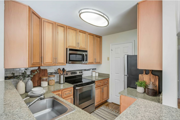 Alexandria apartment for rent - A kitchen with wooden cabinets and a black refrigerator.