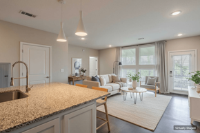Nashville apartment for rent - A kitchen with granite countertops and a dining area with a white table and chairs.