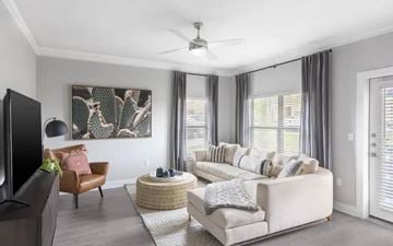 Overland Park apartment for rent - A living room with a white couch, a brown chair, and a painting on the wall.