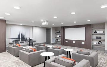 Overland Park apartment for rent - A modern living room with grey couches and a large screen on the wall.