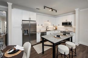 Buford apartment for rent - A modern kitchen with a dining table set for two.