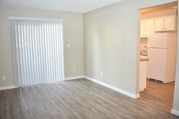 Reno apartment for rent - A kitchen area with a refrigerator and cabinets is visible through an open door.