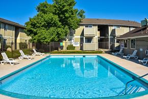 Reno apartment for rent - A swimming pool in front of apartment buildings with sun loungers around it.