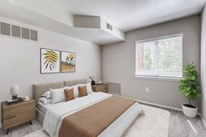 Broomfield apartment for rent - A bedroom with a large bed and a potted plant.