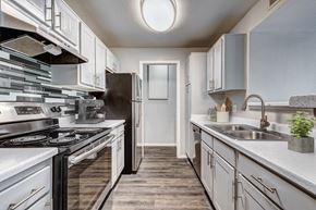 Broomfield apartment for rent - A modern kitchen with a black stove top oven and white cabinets.