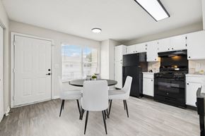 Gallatin apartment for rent - A kitchen with a table and chairs in front of a white door.