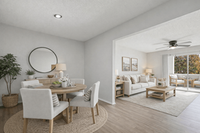 Smyrna apartment for rent - A well-lit, modern dining room with a round mirror and a wooden table.