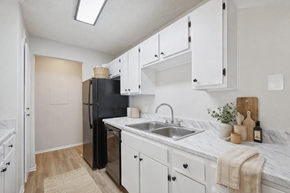 Smyrna apartment for rent - A kitchen with white cabinets and a black fridge.