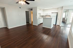 Pearl apartment for rent - an empty living room and kitchen with wood flooring and a ceiling fan