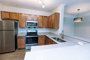 Murfreesboro apartment for rent - A kitchen with wooden cabinets and stainless steel appliances.