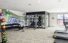 Hunstville apartment for rent - A gym with a row of dumbbells on the left and a row of treadmills on the right.