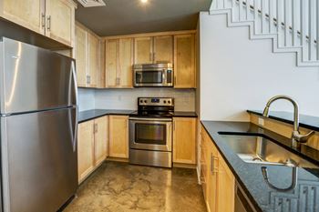 A kitchen with stainless steel appliances and wooden cabinets