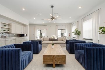 Nashville apartment for rent - A modern living room with a long wooden table and blue velvet chairs.