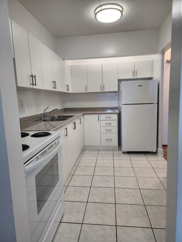 Toronto apartment for rent - A kitchen with white appliances and cabinets.