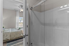 Castle Hayne apartment for rent - A bedroom with a bed and a glass door leading to a bathroom.