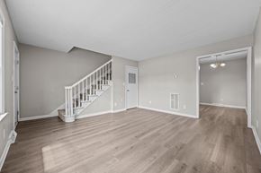 Jacksonville apartment for rent - A spacious room with a staircase and a door leading to another room.