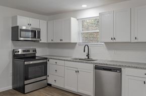 North Charleston apartment for rent - a kitchen with white cabinets and stainless steel appliances and a sink