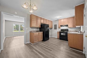 Jacksonville apartment for rent - A kitchen with wooden cabinets and a black refrigerator.