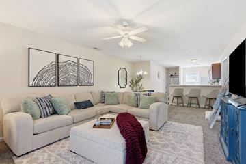 Fayetteville apartment for rent - A living room with a white couch and a red throw on it.