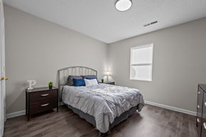 Kernersville apartment for rent - A bedroom with a bed, nightstand, and window.