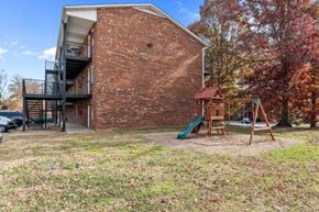 Kernersville apartment for rent - A red brick building with a playground in front.
