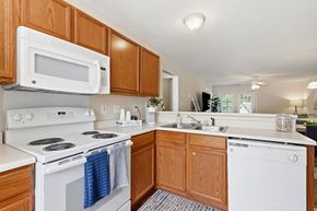 Fayetteville apartment for rent - A white stove and oven in a kitchen with wooden cabinets.