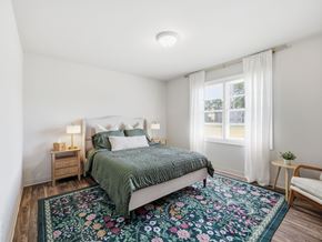 Jacksonville apartment for rent - A bedroom with a bed, nightstands, and a rug.