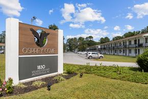Jacksonville apartment for rent - A sign for Osprey Cove is in front of a building.