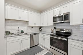 Sanford apartment for rent - A kitchen with white cabinets and a black stove top oven.