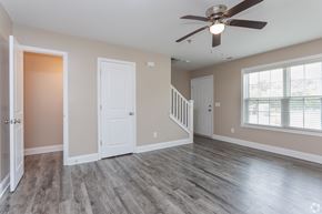 Jacksonville apartment for rent - A room with a ceiling fan and wooden flooring.