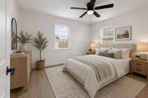 North Charleston apartment for rent - A bedroom with a large bed, a ceiling fan, and a plant on the side table.