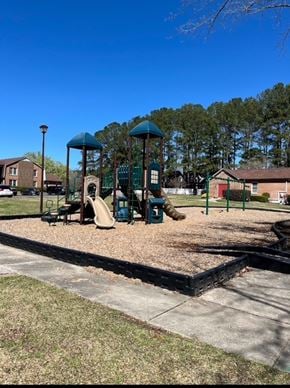 Fuquay-Varina townhouse for rent - A playground with a slide and a swing set.