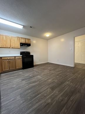 Fuquay-Varina townhouse for rent - A kitchen with wooden cabinets and a black oven.