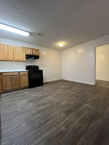Fuquay-Varina townhouse for rent - A kitchen with wooden cabinets and a black oven.