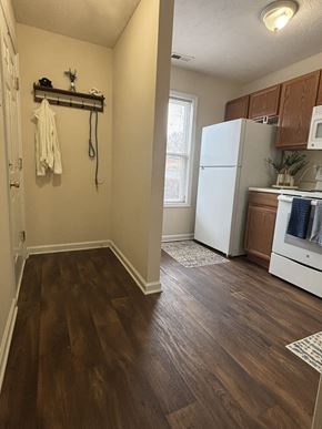 Fayetteville apartment for rent - A white refrigerator is in a kitchen with wood floors.