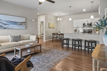 Longs apartment for rent - A living room with a white couch and a painting of a beach scene on the wall.