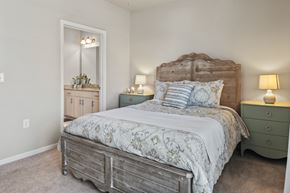 Longs apartment for rent - A bedroom with a large bed and a dresser with a mirror.