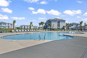 Longs apartment for rent - A large swimming pool with a slide and a building in the background.