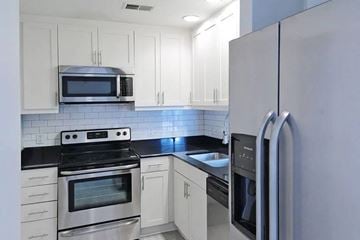 Columbia apartment for rent - A kitchen with white cabinets and a black countertop.