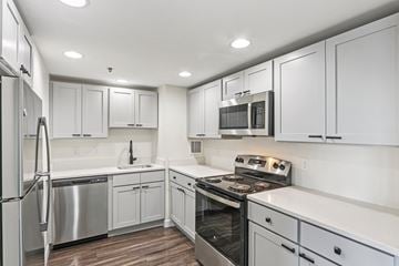 Boston apartment for rent - A modern kitchen with white cabinets and stainless steel appliances.