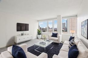 Boston apartment for rent - A living room with white furniture and a flat screen TV.
